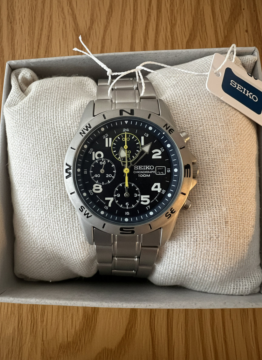Seiko watch with blue face and silver case on a textured cushion, brand tag visible